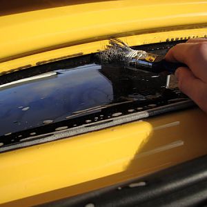 Using a 1" 25mm brush, and car shampoo mixed with water, you can remove a lot of dirt trapped between the glass and rear metal surround of the boot.